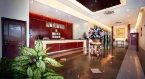 a large kitchen with red cabinets and plants in a room at Kingwood Hotel Mukah in Mukah