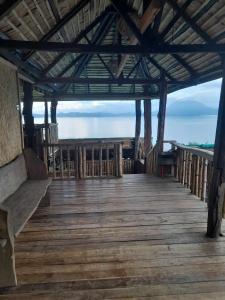 a wooden deck with a view of the ocean at Waddy Inn and Leisure Farm in Taytay +2 photos