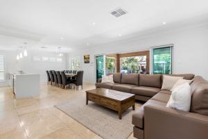 Callala BeachにあるSunkissed Manor - Swimming Pool - 3 Mins to Beachのソファとテーブルのあるリビングルーム
