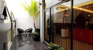 a balcony with a table and chairs and a palm tree at Inn Home Hotel Muar in Kampung Tanjung Agas