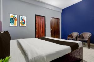 MancheshwarHotel O Palasuni Bridge Bhubaneswar Formerly Ganpat的一间卧室配有一张带蓝色墙壁和椅子的床。 更多23张照片