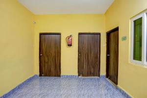 MancheshwarHotel O Palasuni Bridge Bhubaneswar Formerly Ganpat的一间设有两个木门和一个灭火器的房间