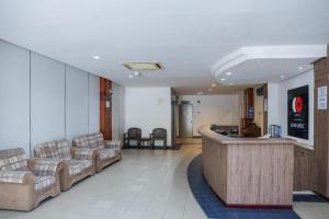 a lobby with couches and a bar in a hospital at Capital O 89876 Safari Hotel in Pasir Bogak