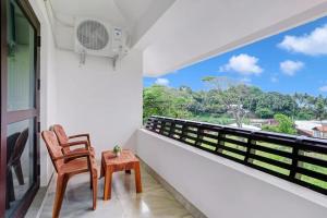 a balcony with a chair and a table and a window at Ocean Queen Palace Kovalam in Trivandrum