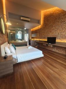 een slaapkamer met een bed en een bakstenen muur bij Loke Thye Kee Heritage Hotel in George Town