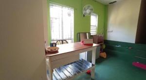 an office with a desk in a room with green walls at SPOT ON 90119 Bed's Guesthouse in Kuching