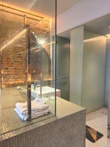 een badkamer met een glazen douche en een wastafel bij Loke Thye Kee Heritage Hotel in George Town