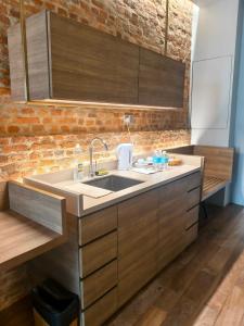 een keuken met een wastafel en een bakstenen muur bij Loke Thye Kee Heritage Hotel in George Town