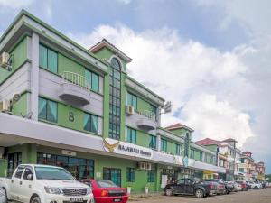 Un edificio con coches aparcados en un estacionamiento. en Rajawali Homes Kota Marudu, en Kampong Tumsun