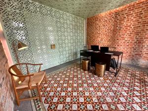 een lege kamer met een piano en een bakstenen muur bij Loke Thye Kee Heritage Hotel in George Town +4 foto's