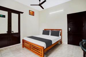 a bedroom with a bed and a ceiling fan at Ocean Queen Palace Kovalam in Trivandrum