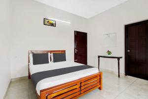 a bedroom with a bed and a table in it at Ocean Queen Palace Kovalam in Trivandrum
