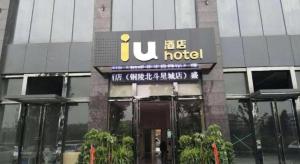 a building with a hotel sign in front of it at IU Hotels·Tongling Beidouxingcheng in Tongling