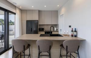 a kitchen with a island with four bar stools at Cozy Home In Dingac With Sauna in Gornji Dingač