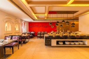 ein Restaurant mit roten Wänden und einer Theke mit Speisen in der Unterkunft Howard Plaza The Fern, Agra in Agra