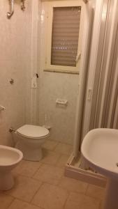 a bathroom with a toilet and a sink and a shower at San Pietro Apartments in San Pietro in Bevagna