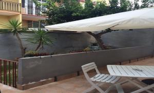 a white umbrella and a table and chair on a patio at Affittacamere di Fabio Principale in Talsano