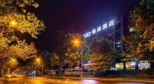 a city street at night with a building with lights at Xana Hotelle· Dalian Software Park University of Technology in Dalian