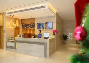 a woman sitting at a counter in a lobby at City Comfort Inn Baise Jinxiuguoji in Qitang +119 photos