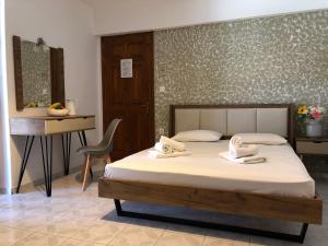 Un dormitorio con una cama, un escritorio y una silla. en Armonia Guest House, en Skiathos