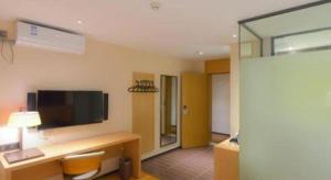 a hotel room with a desk and a television in a room at IU Hotels·Anshun Nanma Square in Anshun +89 photos