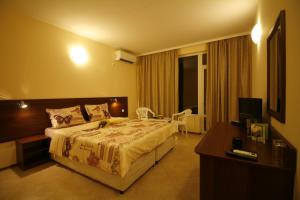 a hotel room with a bed and a television at Hotel Marant in Sozopol