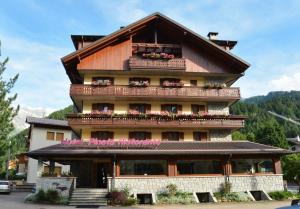 a large building with balconies and flowers on it at Hotel Pineta in Ponte di Legno