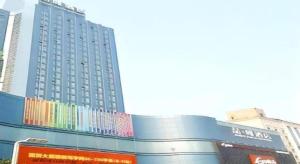 石家庄James Joyce Coffetel Shijiazhuang the Mixc Xinbai Plaza Metro Station的一座蓝色的大楼，上面有彩色的标志