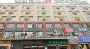 ein Gebäude mit einem Schild an der Vorderseite in der Unterkunft Jinjiang Inn Wuhan Wujiashan Development District Branch in Wuhan