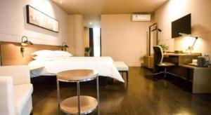 Una habitación de hotel con una cama, una mesa y un sofá. en Jinjiang Inn select Hotel Kunming Economic Development Zone Kunming College, en Kunming