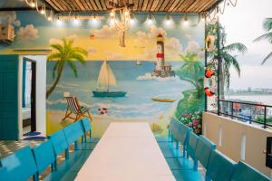 ein Zimmer mit einem Wandgemälde von einem Strand und einem Leuchtturm in der Unterkunft Santori Homestay Nhật Lệ in Dong Hoi + 37 Fotos