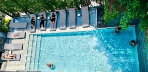 a group of people swimming in a swimming pool at ISTY Design Hotel in Chiang Mai