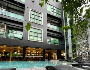 a building with a swimming pool in front of a building at ISTY Design Hotel in Chiang Mai