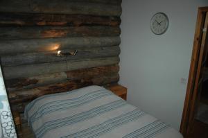 ルカにあるChalets Revonaapa A 5のベッドルーム1室(ログウォール、ベッド1台、時計付)