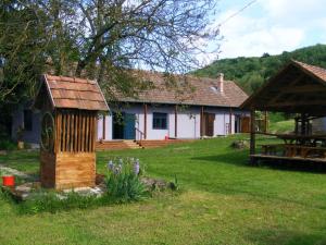 a house with a wooden structure in a yard at Bakancstanya in Kétbodony