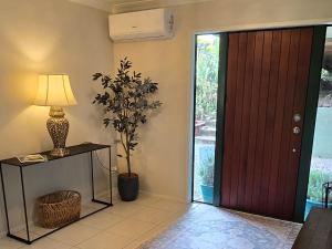 a room with a door and a lamp and a plant at Chestnut Bay Country Retreat in Whakamarama