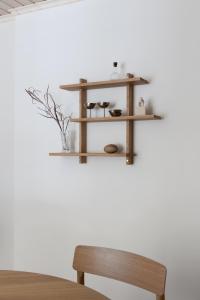 a wooden shelf on a wall with a wooden bench at Stylish & Cozy 1BR Apt in Historical Neighborhood in Tampere