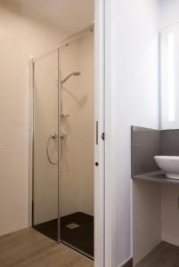 La salle de bains est pourvue d'une douche avec une porte en verre. dans l'établissement Albergue Linares, à Saint-Jacques-de-Compostelle