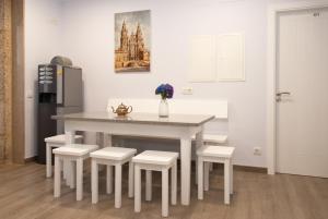 a kitchen with a table and chairs and a refrigerator at Albergue Linares in Santiago de Compostela