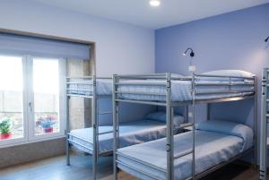 a bunk bed room with two bunk beds and a window at Albergue Linares in Santiago de Compostela