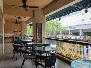 a restaurant with tables and chairs and a bar at SPOT ON 90984 Gn Homestay in Miri