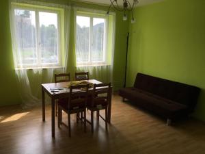 a dining room with a table and chairs and a couch at City Apartment Děčín in Děčín