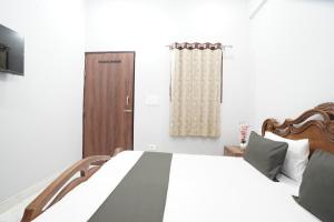 a bedroom with a bed and a wooden door at CITY CHARM Home Stay in Dehradun