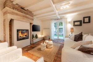 ブランケンベルヘにあるMaison 42の白いソファと暖炉のあるリビングルーム