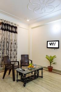 een woonkamer met twee stoelen en een tafel bij Hotel Warm Welcome Inn 51 in Noida