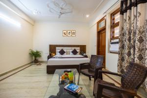 een slaapkamer met een bed, een tafel en stoelen bij Hotel Warm Welcome Inn 51 in Noida +37 foto's