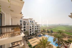 uma vista para a piscina a partir da varanda de um hotel em Two - Bedroom Crown Jewel on Yas island by Ayla em Yas Island