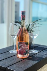 a bottle of alcohol sitting on a table with two glasses at The Beach House in Chichester
