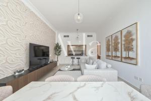 uma sala de estar branca com um sofá e uma TV em Two - Bedroom Crown Jewel on Yas island by Ayla em Yas Island