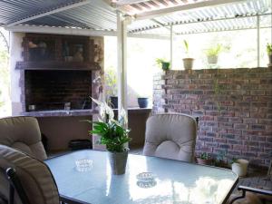 a patio table with chairs and a brick wall at Lily Guesthouse in Bloemfontein